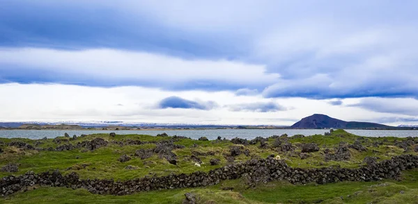 Rocas Volcánicas Muros Contención Prado Islandia Frente Lago Una Cordillera — Foto de Stock
