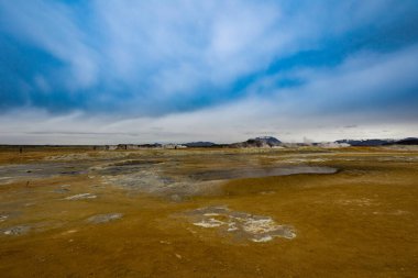 İzlanda manzarası Mars yüzeyine benziyor. Sarı zemin ve mavi akarsular. Buhar, mavimsi sülfat maddesiyle dolu kaynayan çukurlardan çıkıyor.