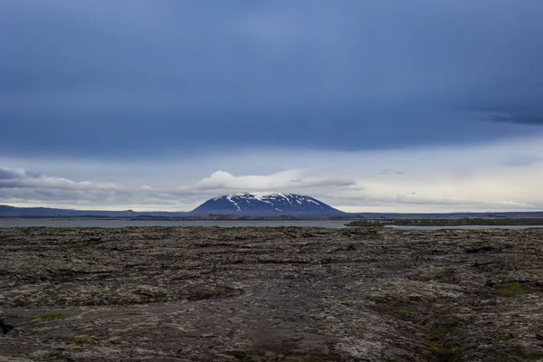 Roca Volcánica Frente Lago Montañas Cubiertas Nieve Islandia Durante Verano — Foto de Stock