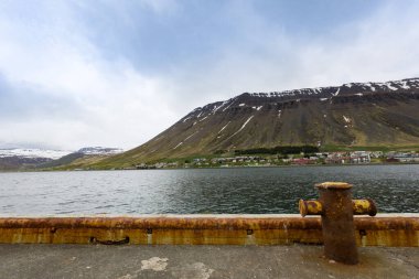 Kuzey İzlanda limanında körfezin diğer tarafındaki dağ sıralarında robotlara bilgi vermek için paslı metal anketi