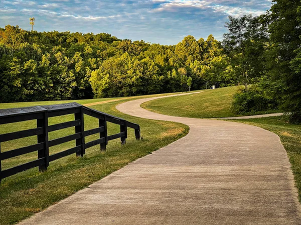 Lexington, Kentucky 'deki Gazi parkında ilerleyen bir yolun kıvrımları. Görüntünün sol tarafında tahta çit var. 