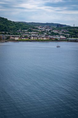 Sailboat anchored close to British coastline. Plenty of copy space on the water surface on the bottom part of the picture.