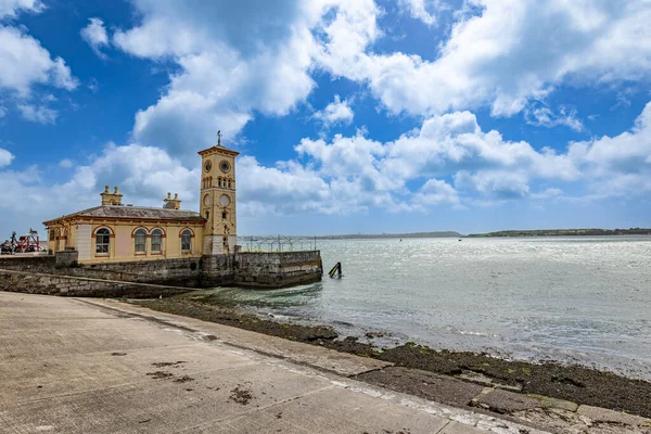 Building with clock tower build inside the water of the coastline in Cobh in Co Cork, Ireland
