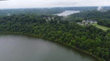 Approaching a forest on the coastline of Taylorsville lake in central Kentucky during misty, rainy day with low hanging clouds 