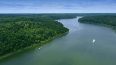 Speed boats traffic enjoying each others waves in the branches of Taylorsville lake surrounded by tick forest in Central Kentucky