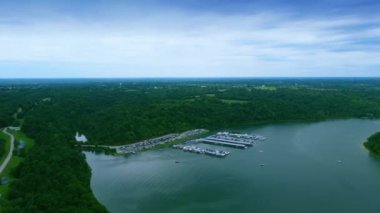 Flying over Taylorsville Lake Marina in Central Kentucky. Private boats docked on the water pier and cars parked in dedicated parking lots.