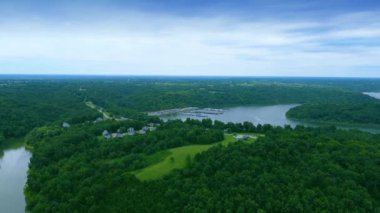 Approaching from the air Taylorsville Lake Marina flying over a hill with vacation homes build close to the waters edge.