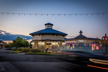 Lexington, Kentucky USA - August 16 2022: Night traffic is crossing in front of storefronts of Hamburg area shopping mall in Lexington, Kentucky