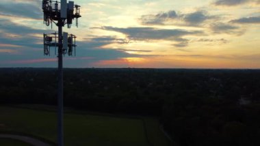 Pulling away from cell phone wireless transmission tower during bright red and orange sunrise