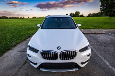 Lexington, Kentucky ABD - Sep 7 2022: 2017 BMW X1 'in gün batımında Jacobson parkında çimlerin önündeki park noktasının ön görüntüsü.