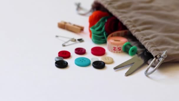 白を基調とした生地の袋からこぼれる縫製用品のクローズアップ — ストック動画