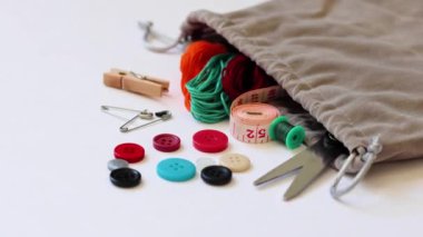 Dikiş malzemeleri beyaz arkaplana yayılmış.