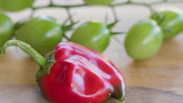 Pequeño Pimiento Rojo Deformado Sobre Fondo Del Manojo Tomates Cherry — Vídeos de Stock