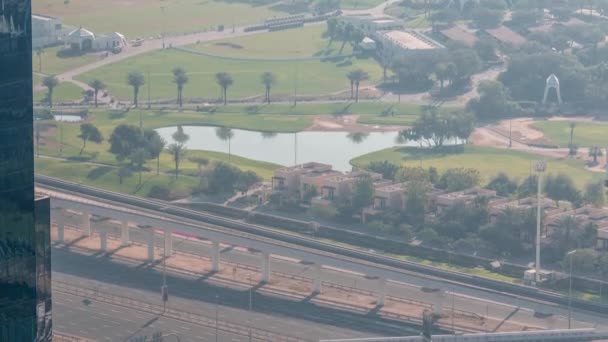 Aerial view to Golf course with green lawn and lakes, villa houses behind it timelapse. — Stock Video