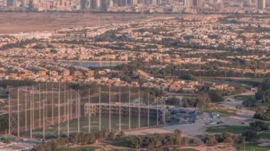 Yeşil çimenli ve göllü Golf sahasına hava manzaralı, arkasında villalar olan villalar zaman ayarlı..