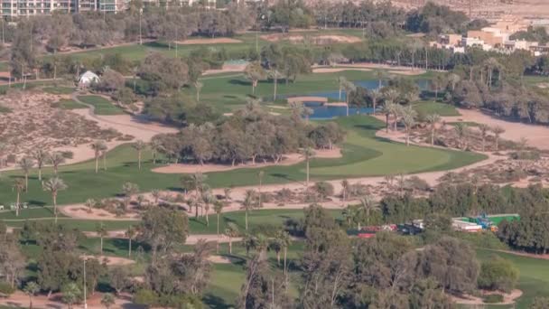Αεροφωτογραφία στο γήπεδο γκολφ με πράσινο γκαζόν και λίμνες, βίλα σπίτια πίσω από αυτό timelapse. — Αρχείο Βίντεο