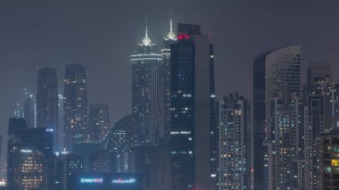 Dubai gökdelenleri aydınlatma ve pencereleri aydınlatma ile iş sahasında gece zaman dilimi. Birleşik Arap Emirlikleri 'nin şehir merkezinden hava görüntüsü.
