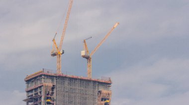 Vinçler yeni gökdelen zaman çizelgesinin modern soyutlama sahasında çalışıyor. Hızlı kentsel gelişim etkinliği kutsa ve inşa et