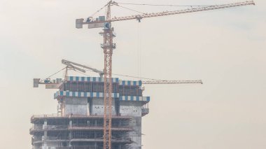 Vinçler yeni gökdelen zaman çizelgesinin modern soyutlama sahasında çalışıyor. Hızlı kentsel gelişim etkinliği kutsa ve inşa et