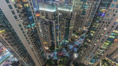 Gökdelenlerin gökdelenleri akşam saatlerinde Dubai şehir merkezinde perspektiften aşağı bakıyor. Kuleler arasındaki yolda trafik olan aydınlık evler