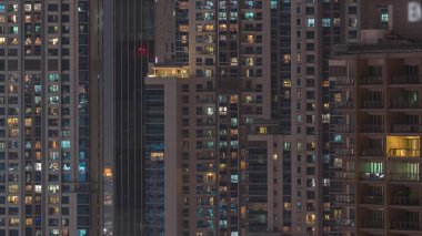 Gecenin ilerleyen saatlerinde gökdelenlerin dış tarafındaki pencereler zaman ayarında parıldıyor ve yanıp sönüyor. Havadan üst görünüm