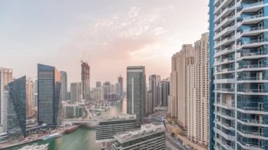 Kanal çevresindeki Dubai marina gökdelenlerine gün be gece yüzen teknelerle hava görüntüsü