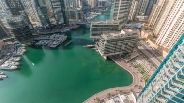 Kanal çevresindeki Dubai marina gökdelenlerine tüm gün yüzen teknelerle hava görüntüsü