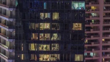 Modern ofisteki pencere ışıkları ve konut binaları geceleri zaman ayarlı