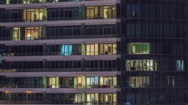 Modern ofisteki pencere ışıkları ve konut binaları geceleri zaman ayarlı