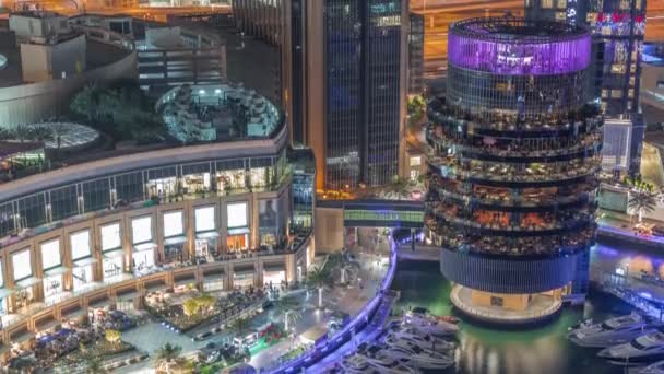 Dubai marina beira-mar e edifício com diferentes restaurantes em cada andar aéreo noite timelapse. — Vídeo de Stock