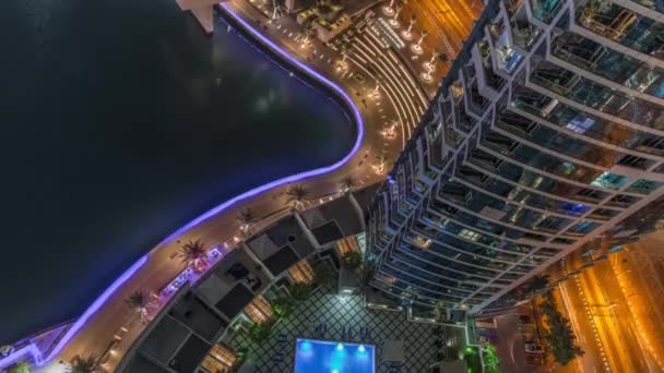 Dubai jachthaven promenade aan de waterkant langs kanaal antenne nacht timelapse. — Stockvideo