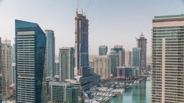 Aerial view to Dubai marina skyscrapers around canal with floating boats timelapse — Stock Video