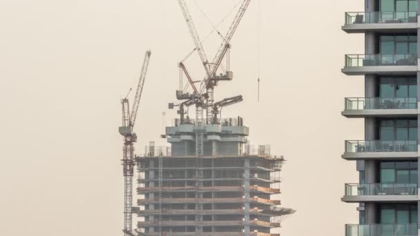 Arranha-céu em construção com guindastes e estrutura de ferro timelapse — Vídeo de Stock