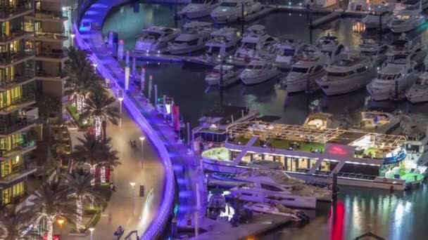 Luchtfoto naar Dubai jachthaven waterkant rond kanaal met drijvende boten nachtelijke timelapse — Stockvideo