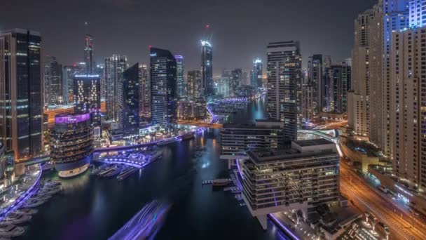 Luchtfoto naar Dubai jachthaven wolkenkrabbers rond kanaal met drijvende boten de hele nacht timelapse — Stockvideo