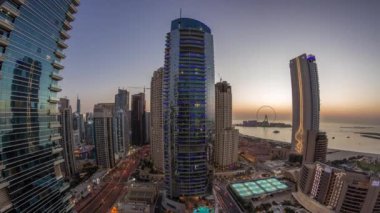 Dubai Marina ve JBR bölgesinin panoraması ve ünlü dönme dolap hava gününden geceye zaman çizelgesi.