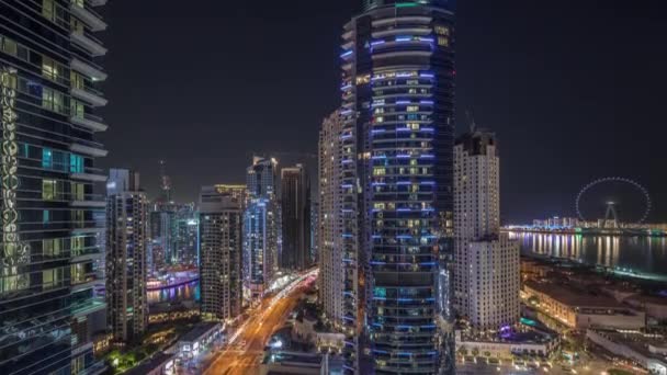 Panoramic view of the Dubai Marina and JBR area and the famous Ferris Wheel aerial night timelapse — Stock Video