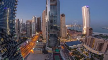 Dubai Marina ve JBR bölgesinin panoramik manzarası ve ünlü dönme dolabın gece gündüz görüntüsü.