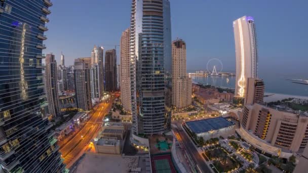 Panoramisch uitzicht op de Dubai Marina en JBR gebied en de beroemde Ferris Wiel antenne nacht tot dag timelapse — Stockvideo