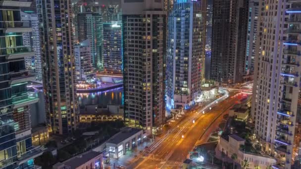 Вид с воздуха на небоскребы Dubai Marina и самую роскошную яхту в гавани ночью timelapse, Дубай, Объединенные Арабские Эмираты — стоковое видео