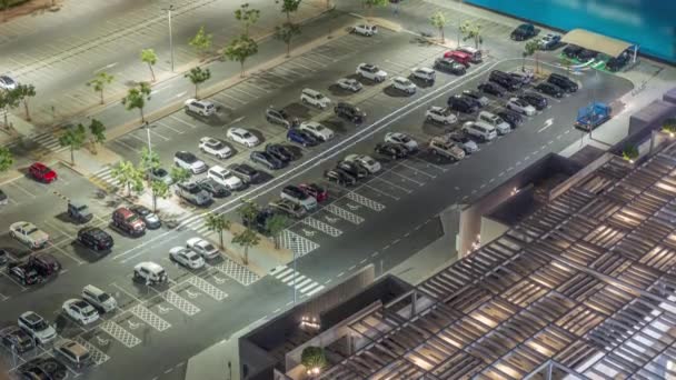 Top View zajęty parking z wieloma samochodami poruszających się w i na zewnątrz nocy timelapse. — Wideo stockowe