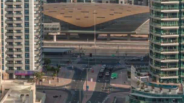 Doprava na křižovatce v blízkosti tramvajové zastávky a výstup ze stanice metra na pozadí v dubajském přístavu letecké timelapse — Stock video