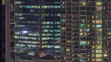 Geceleri apartman pencereleri ve ofis binaları, evlerin pencerelerinden gelen ışık.