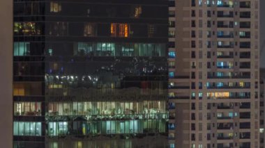 Apartman binalarının pencereleri ve ofis saatleri, evlerin pencerelerinin ışığı.