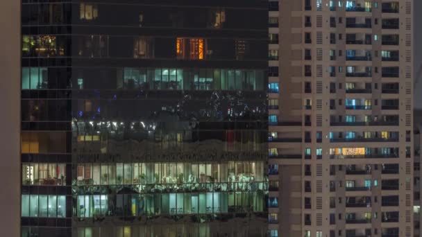 Fönster av lägenhetsbyggnader och kontor på natten timelapse, ljuset från fönstren i hus — Stockvideo