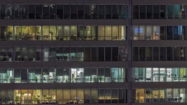 Geceleri ofis binalarının pencereleri, evlerin pencerelerinin ışığı.