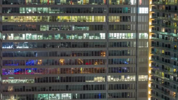 Окна офисных зданий в ночное время, свет из окон домов — стоковое видео