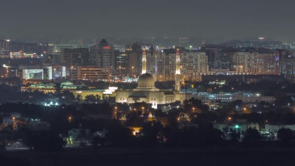 Caminin ve Deira 'nın hava manzarası arka plandaki gece programında. Dubai, Birleşik Arap Emirlikleri — Stok video