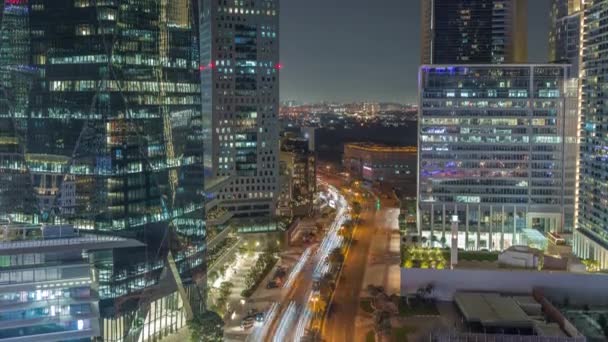 Trafik på en väg i Dubai International Financial District antenn natt timelapse. Panoramautsikt över affärs- och finanskontorstorn. — Stockvideo