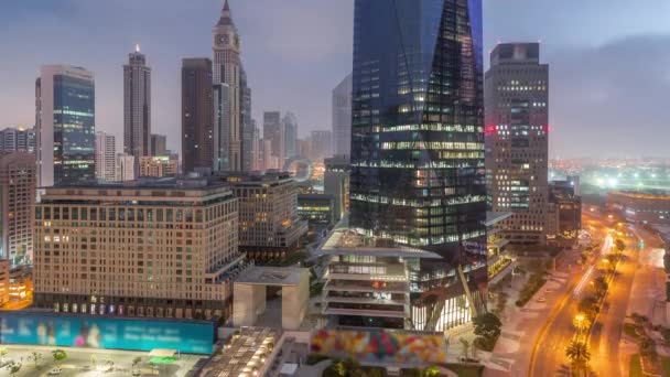 Dubai International Financial distrito aéreo noche al día timelapse. Vista de las torres de oficinas comerciales. — Vídeo de stock